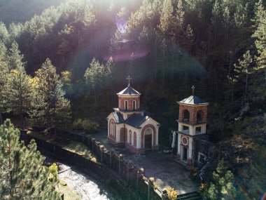 Tara Dağları 'ndaki Ortodoks Kilisesi. Sırbistan' da güneş ışığı ve taş çan kulesi var. g.