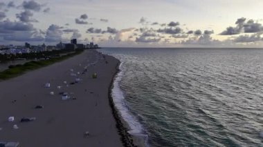 Gündoğumunda ya da batımında ufuk çizgisi ve kumlu kıyısı olan Miami sahili geniş hava manzaralı. g.