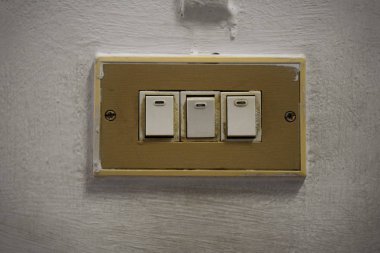 Eski duvardaki üç vintage elektrik ışığı düğmeye
