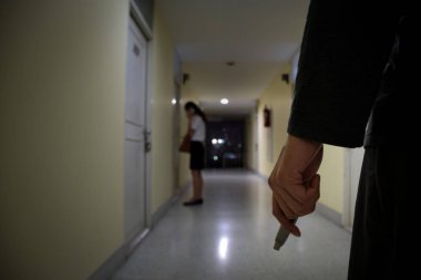 Hırsız ya da hırsız el çakısı kapısında cep telefonu kullanan iş kadınına bakıyor, erkek eli üzerinde duruyor, suç kavramı