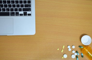 basit yukarıdan tıp uyuşturucu hap, şişe ve tablet bilgisayar ahşap arka plan üzerinde