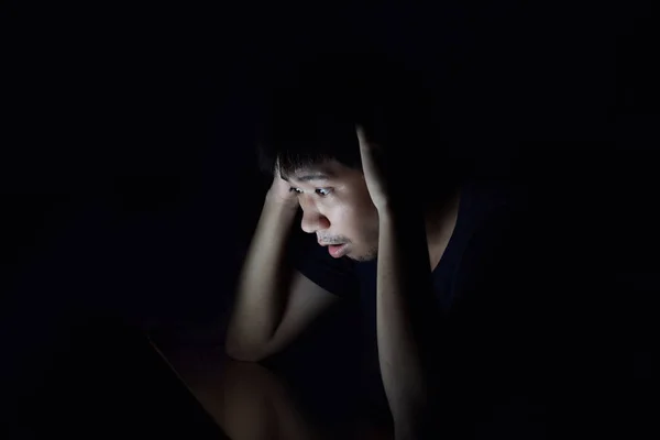 Akıllı telefon siyah karanlık odada kullanarak ve bir şey düşünüyorum Asya adam