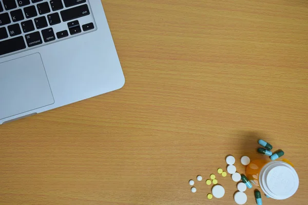 basit yukarıdan tıp uyuşturucu hap, şişe ve tablet bilgisayar ahşap arka plan üzerinde