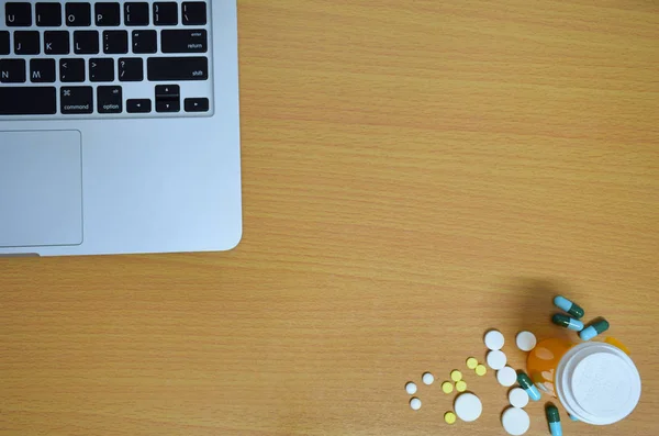 basit yukarıdan tıp uyuşturucu hap, şişe ve tablet bilgisayar ahşap arka plan üzerinde