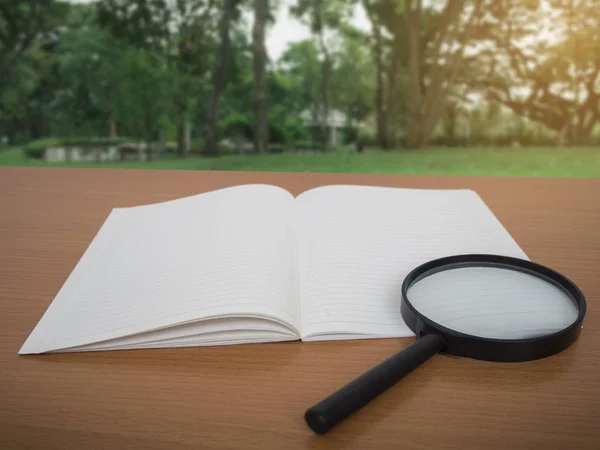 Weergave Van Notebook Vergrootglas Houten Tafel Met Groene Boom Achtergrond — Stockfoto