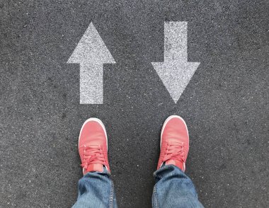 Asfalt yol üzerinde ayak ve farklı yön okları üstten görünüm