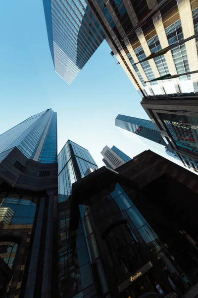 bottom view of skyscrapers in business district of Hong Kong against clear blue sky