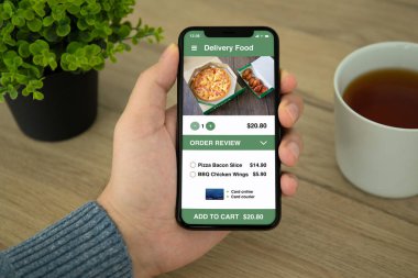 adam el üstünde belgili tanımlık perde telefon app suşi yemek teslim ile tutarak