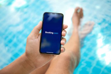 Koh Samui, Tayland - 22 Mart 2018: iphone X uygulama Booking.com online otel rezervasyonları ile ekranda tutan adam el. iPhone 10 oluşturuldu ve Apple Inc tarafından geliştirildi.