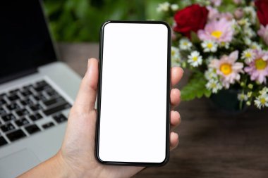 el ile izole perde telefon Danışma dizüstü bilgisayar ve çiçekler üzerinde tutarak