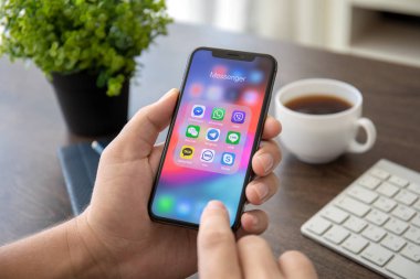 Aluşta, Rusya - 30 Temmuz 2018: sosyal ağ haberci üstünde belgili tanımlık perde ile iphone X tutan adam el. iPhone 10 oluşturuldu ve Apple Inc tarafından geliştirildi.