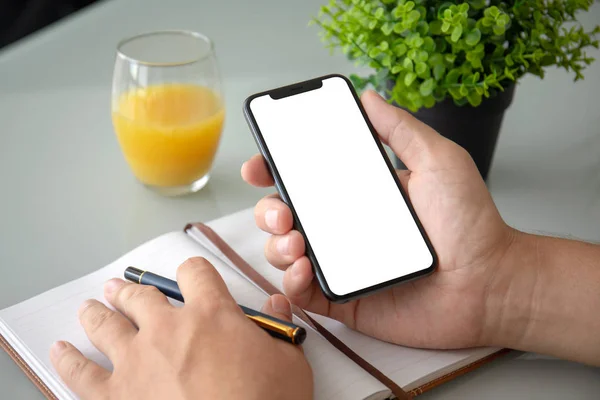 Mann Hält Telefon Mit Isoliertem Bildschirm Händen Und Schreibt Notizbuch — Stockfoto