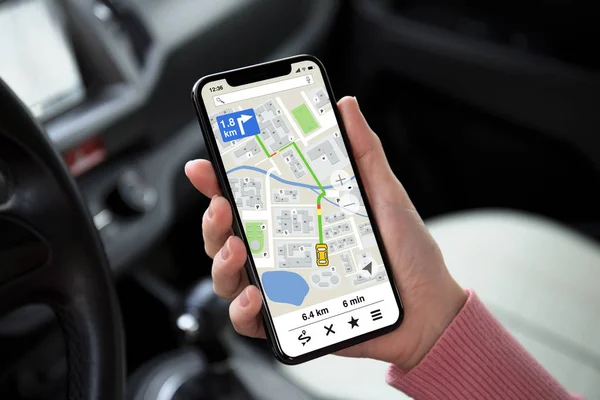 妇女手持手机在屏幕上的应用导航地图在车上 — 图库照片