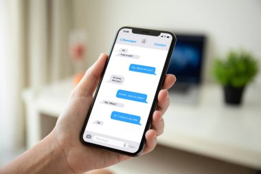 Kadın el evin odasında ekrandaki telefon app messenger ile tutarak