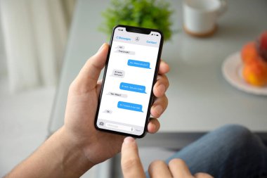 evin odasında ekrandaki telefon app messenger ile tutan adam el