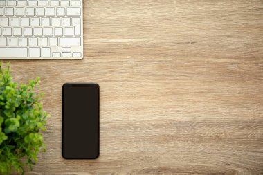 telefon ile siyah ekran klavye ile ahşap masa