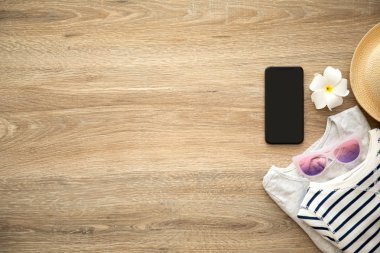 telefon ile giyim ve şeyler için tatil yakın ahşap masa üzerinde siyah perde