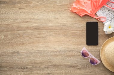 tatil için giysi ve şeyler yakınındaki ahşap masa siyah ekran ile telefon
