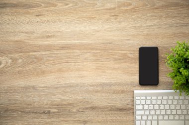 telefon ile siyah ekran klavye ile ahşap masa