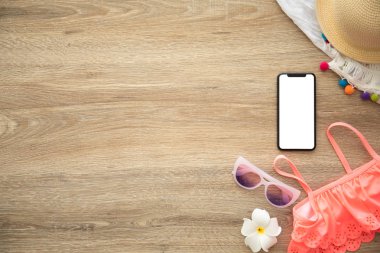 telefon ile giyim ve şeyler için tatil yakın ahşap masa üzerinde izole perde