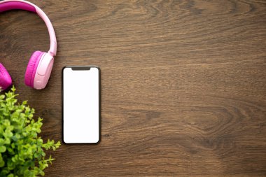 telefon ile izole kulaklık ile ahşap masa ekranda