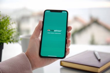Aluşta, Rusya - 24 Eylül 2018: sosyal ağ hizmeti Tripadvisor üstünde belgili tanımlık perde ile iphone X tutan kadın. iPhone oluşturuldu ve Apple Inc tarafından geliştirildi.
