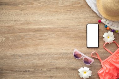 tatil için giysi ve şeyler yakınındaki ahşap masa üzerinde izole ekranlı telefon