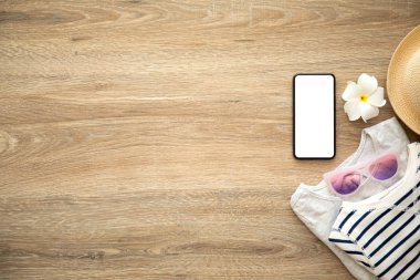 telefon ile giyim ve şeyler için tatil yakın ahşap masa üzerinde izole perde