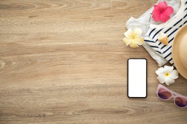 tatil için giysi ve şeyler yakınındaki ahşap masa üzerinde izole ekranlı telefon