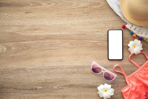 tatil için giysi ve şeyler yakınındaki ahşap masa üzerinde izole ekranlı telefon