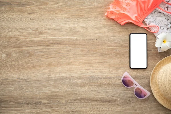tatil için giysi ve şeyler yakınındaki ahşap masa üzerinde izole ekranlı telefon