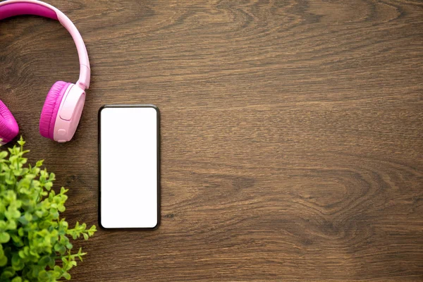 telefon ile izole kulaklık ile ahşap masa ekranda