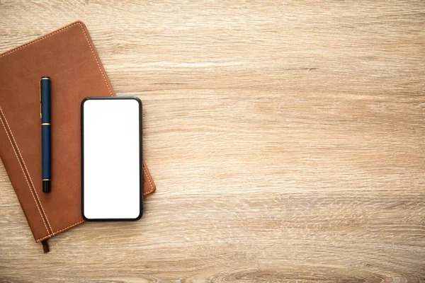 Telefoon Met Geïsoleerde Scherm Houten Tafel Met Een Notebook — Stockfoto