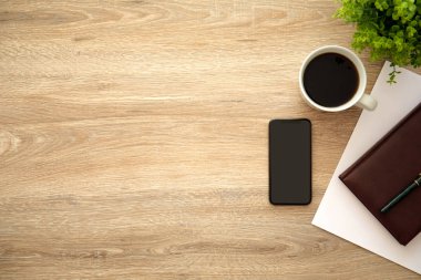 telefon ile defter ve kahve yakınındaki ahşap masa üzerinde siyah perde