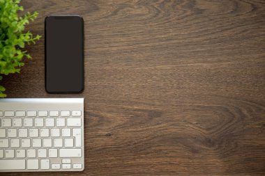 telefon ile siyah ekran klavye ile ahşap masa