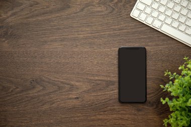 telefon ile siyah ekran klavye ile ahşap masa