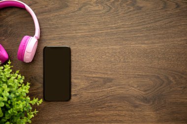 telefon ile kulaklık ile ahşap masa üzerinde siyah perde