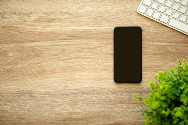 telefon ile siyah ekran klavye ile ahşap masa