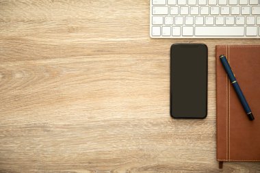telefon ile defter ve klavye ile ahşap bir masa üzerinde siyah perde