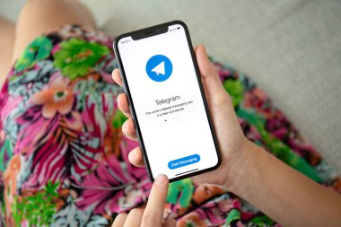 Aluşta, Rusya - 27 Eylül 2018: kadın el iphone X sosyal ağ hizmeti telgraf üstünde belgili tanımlık perde ile tutarak. iPhone 10 oluşturuldu ve Apple Inc tarafından geliştirildi.