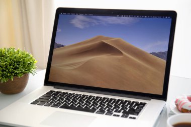 Alushta, Russia - September 28, 2018: Backgrounds MacOS Mojave in the screen of MacBook Pro. MacBook Pro was created and developed by the Apple inc. clipart