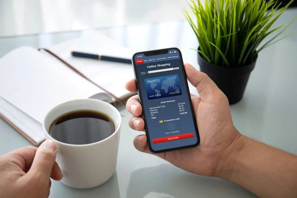 Человек Держит Телефон Приложением Онлайн Покупки Экране Столом Офисе Пьет — стоковое фото