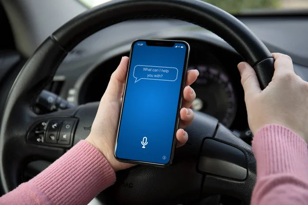 妇女手手持手机与应用程序个人助理在屏幕上的汽车 — 图库照片