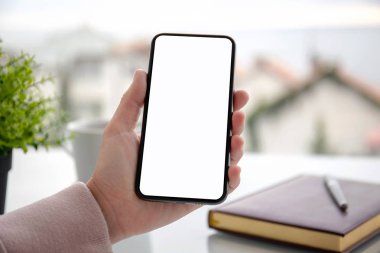 tablonun üst kısmındaki izole ekran ile dokunmatik telefon kafede tutan el