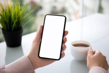 tablonun üst kısmındaki izole ekran ile dokunmatik telefon kafede tutan el