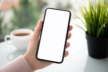 tablonun üst kısmındaki izole ekran ile dokunmatik telefon kafede tutan el