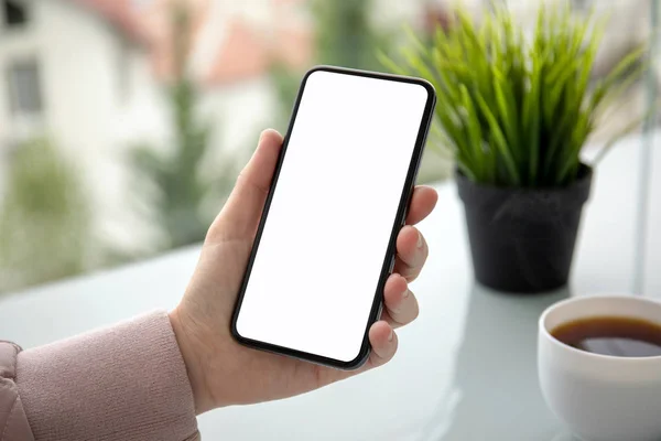 Mano Femenina Sosteniendo Teléfono Táctil Con Pantalla Aislada Sobre Mesa —  Fotos de Stock