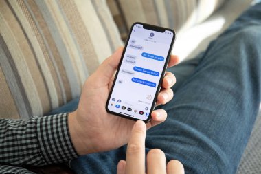 Aluşta, Rusya - 9 Ekim 2018: sosyal ağ hizmeti IMessage ile iphone X ekran üzerinde tutan adam el. iPhone 10 oluşturuldu ve Apple Inc tarafından geliştirildi.