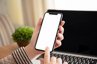 tablonun üst kısmındaki dizüstü bilgisayar ile izole ekran ile dokunmatik telefon ofiste tutmak el
