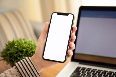 tablonun üst kısmındaki dizüstü bilgisayar ile izole ekran ile dokunmatik telefon ofiste tutmak el